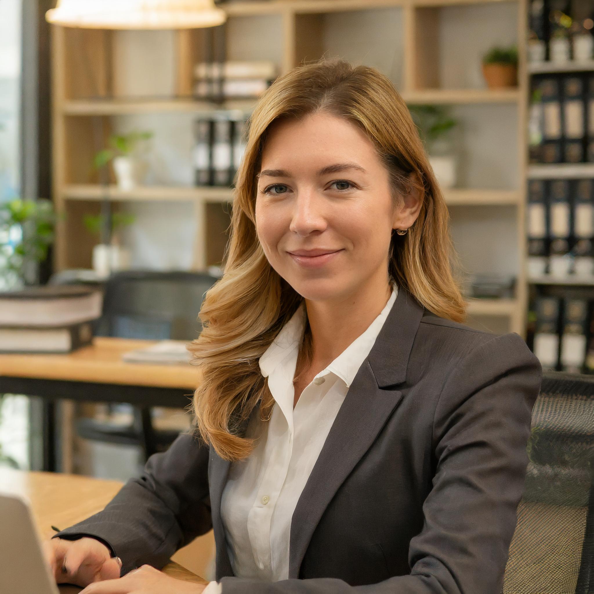 Porträt einer lächelnden, kreativen IT-Expertin am Schreibtisch